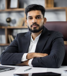 195400243 confident young middle eastern businessman sitting at work table at modern office typing on computer